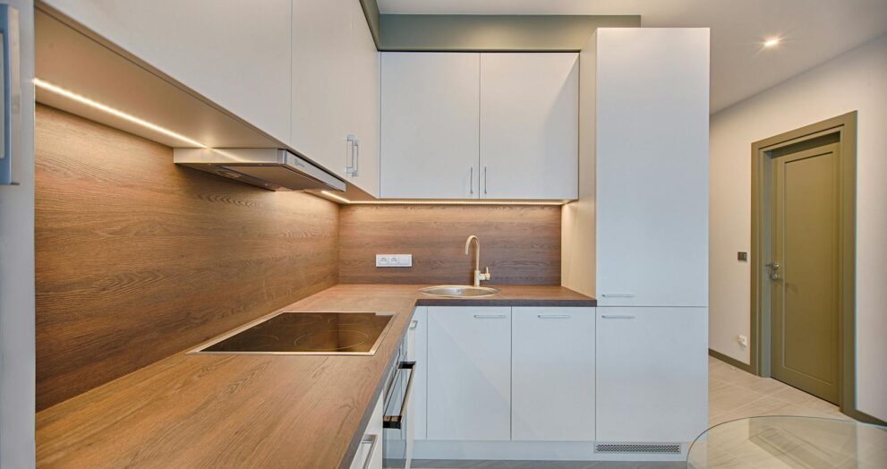 Modern kitchen interior with minimalistic design and wooden accents, captured with natural lighting.