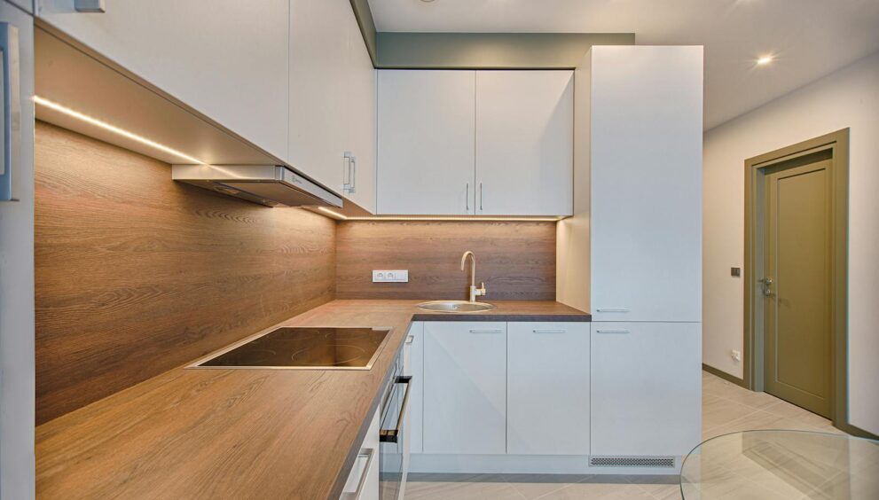 Modern kitchen interior with minimalistic design and wooden accents, captured with natural lighting.